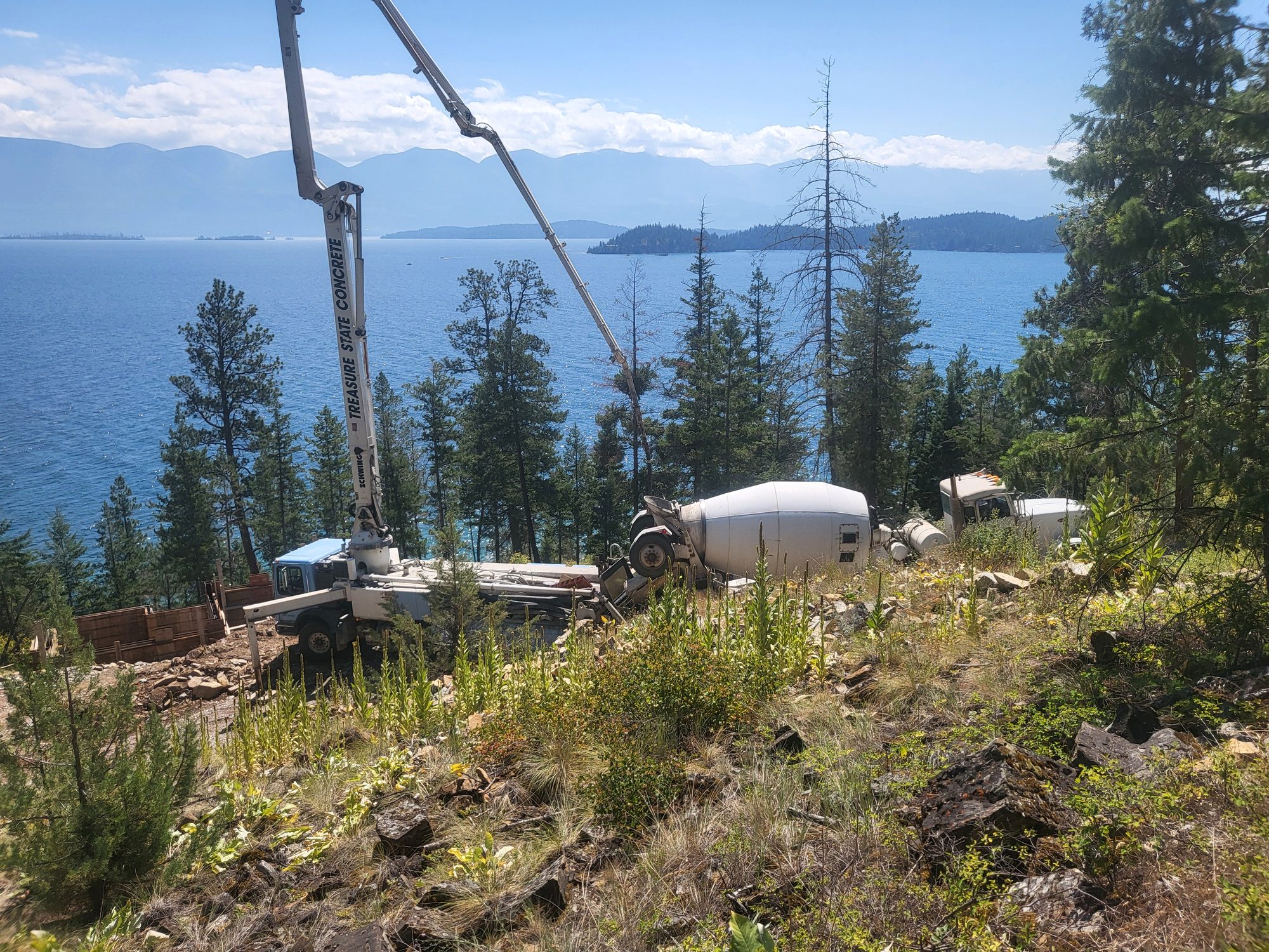 Treasure State Concrete, Inc. concrete pump and mixer working on a steep Montana lakeside jobsite