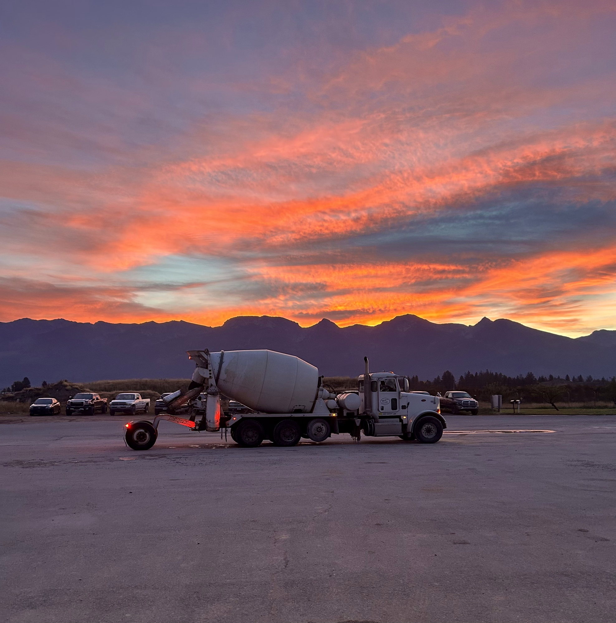 Treasure State Concrete, Inc. mixer truck beneath a vivid Montana mountain sunset